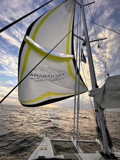  Yacht Photos Pics Lagoon 620 sailing yacht with vibrant spinnaker against a dramatic sky, 2017 model.