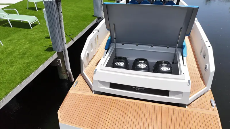  Yacht Photos Pics 2021 De Antonio Yachts D42 with triple 400 horsepower engines, docked near green turf.