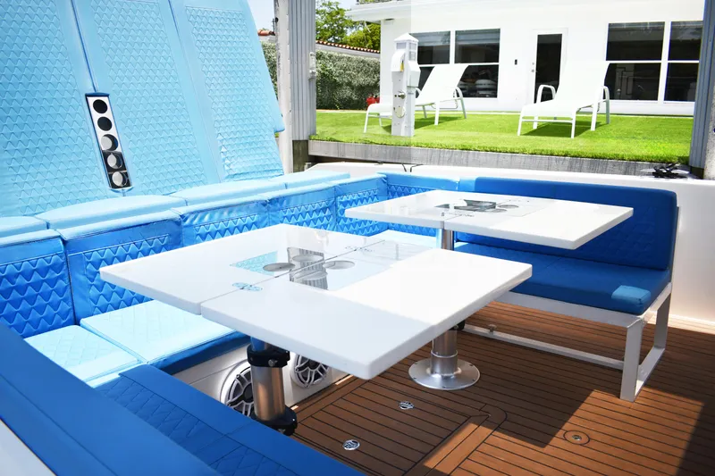  Yacht Photos Pics Luxurious 2021 De Antonio Yachts D42 interior with blue seating and dual tables.
