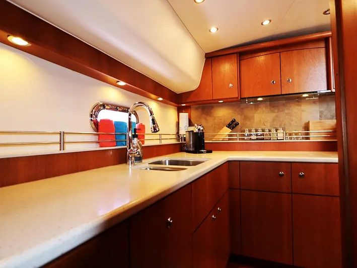 Ocho Yacht Photos Pics Luxurious kitchen interior of 2009 Tiara Yachts 4300 Sovran with wood cabinetry and modern fixtures.