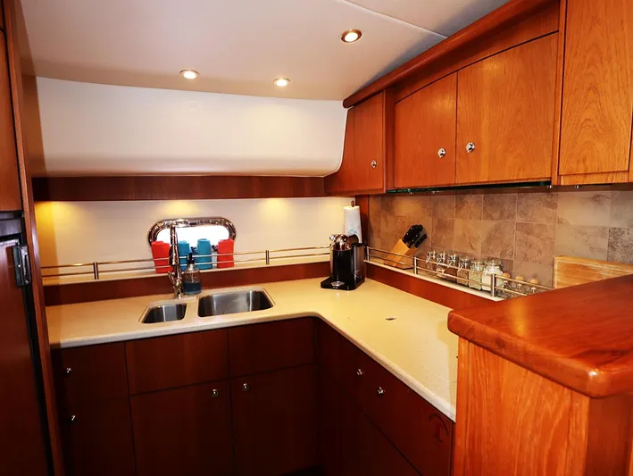 Ocho Yacht Photos Pics Luxurious 2009 Tiara Yachts 4300 Sovran kitchen with wooden cabinets and modern amenities.