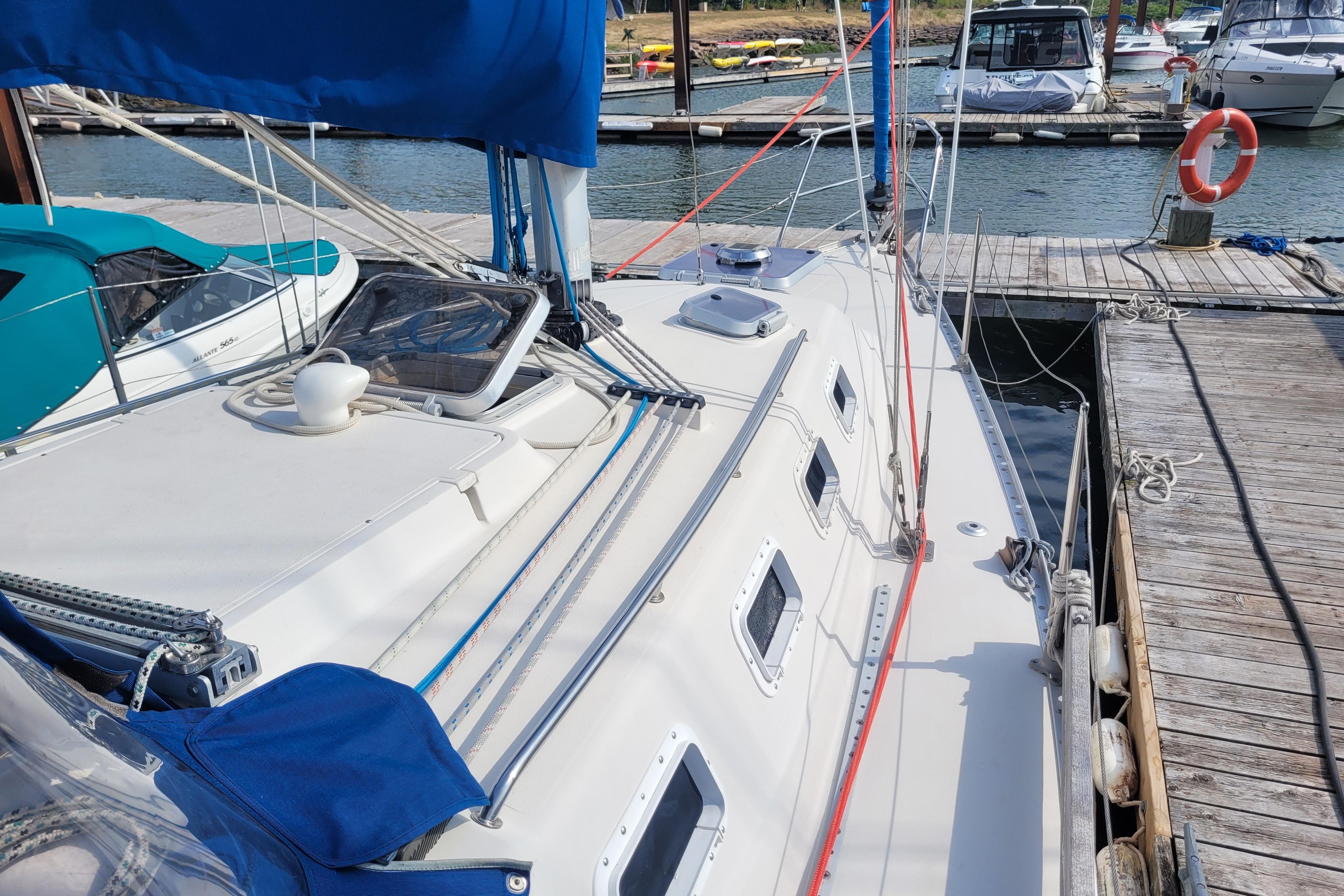 1987 CS 30 sailboat docked at marina, featuring blue sail cover and multiple hatches.