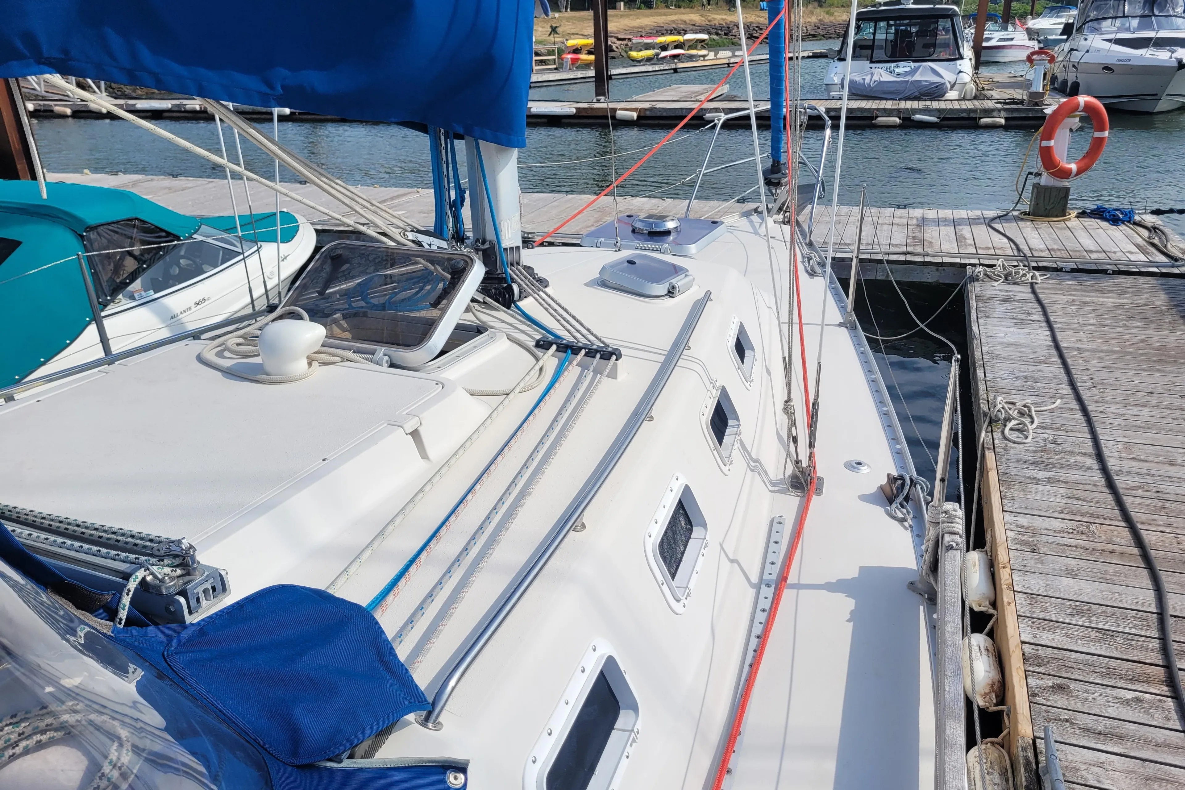 1987 CS 30 sailboat docked at marina, featuring blue sail cover and multiple hatches.