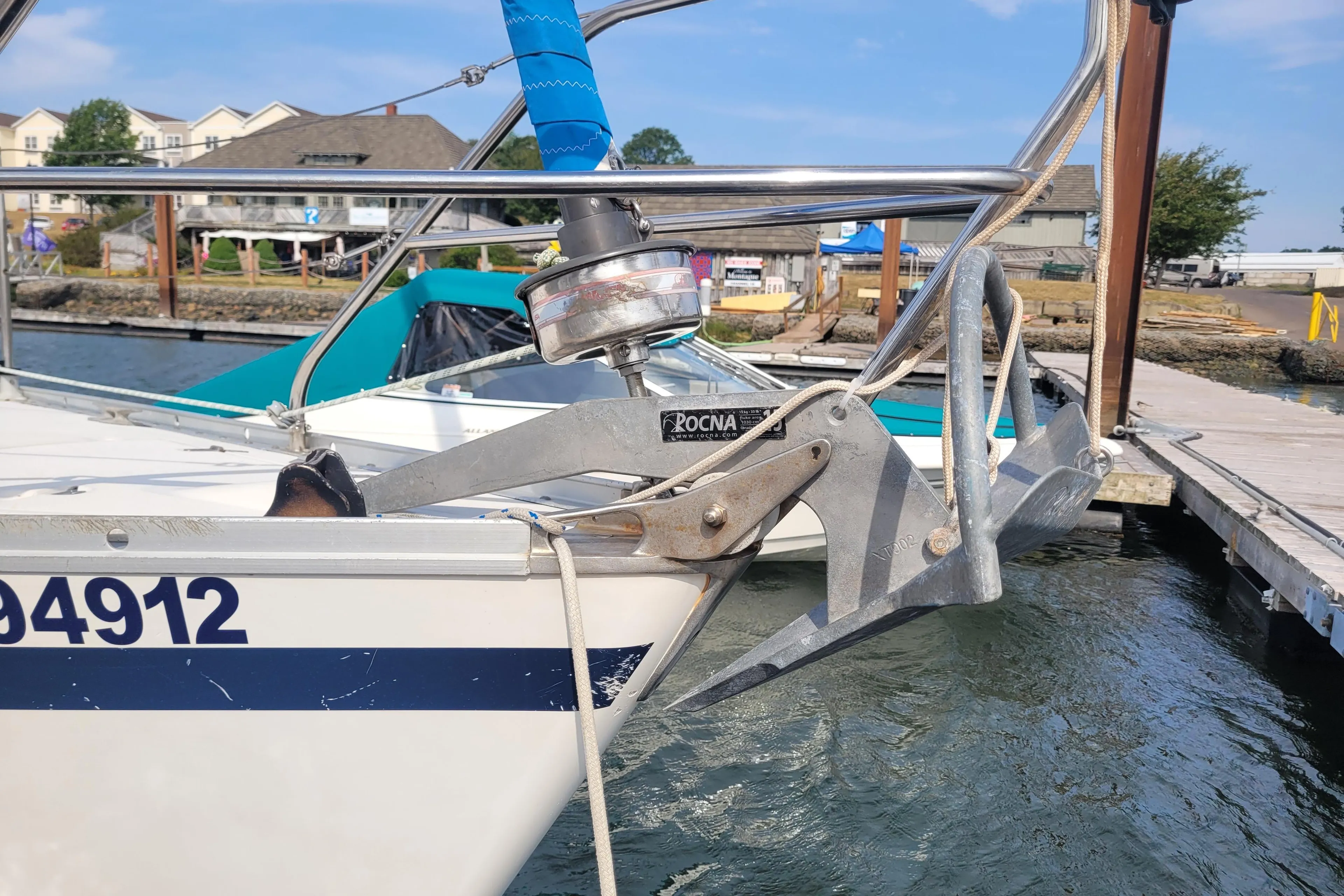 Bow of a 1987 CS 30 sailboat with Rocna anchor at marina dock.