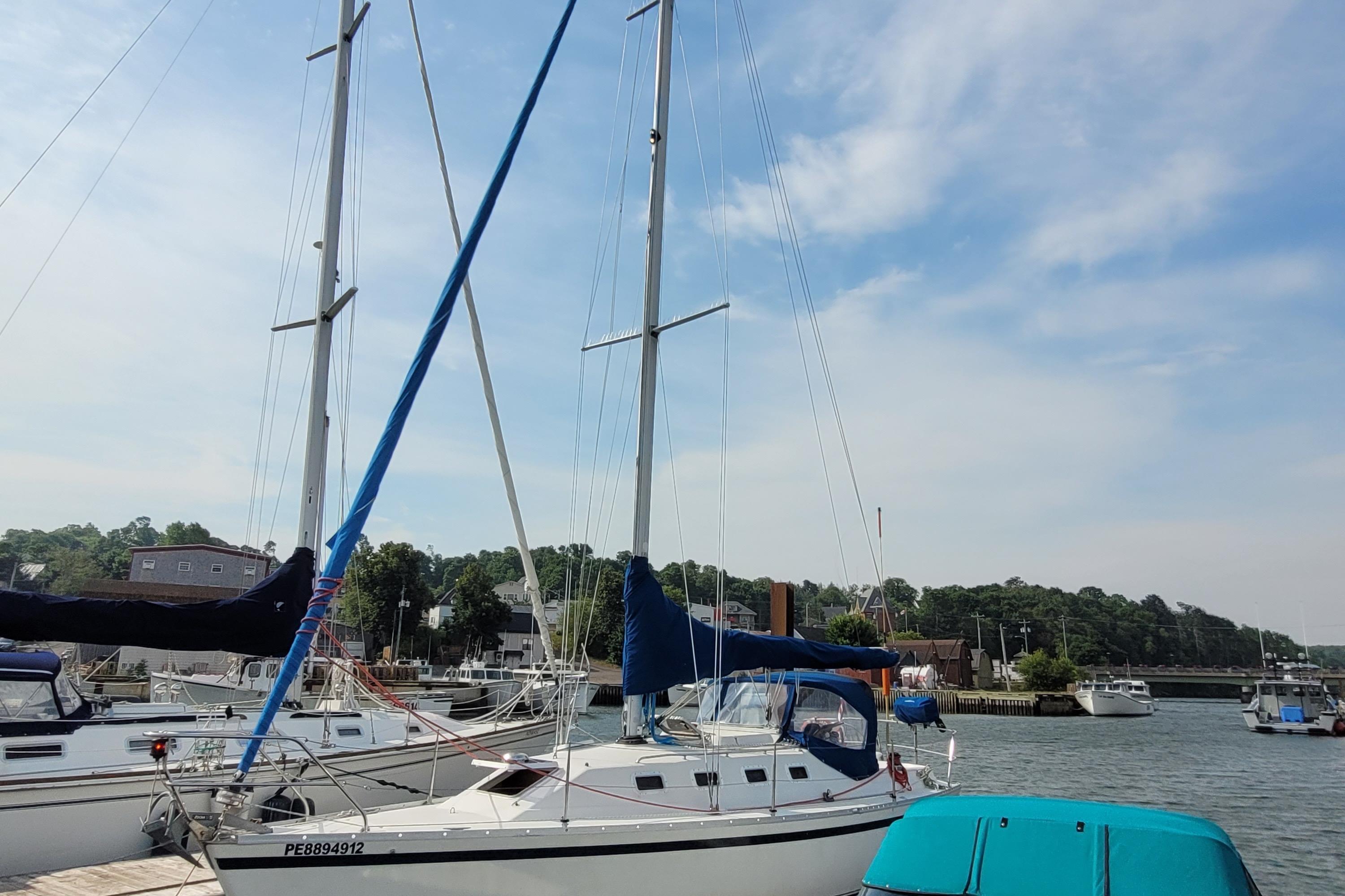 1987 CS 30 sailboat docked in a marina under a clear blue sky.