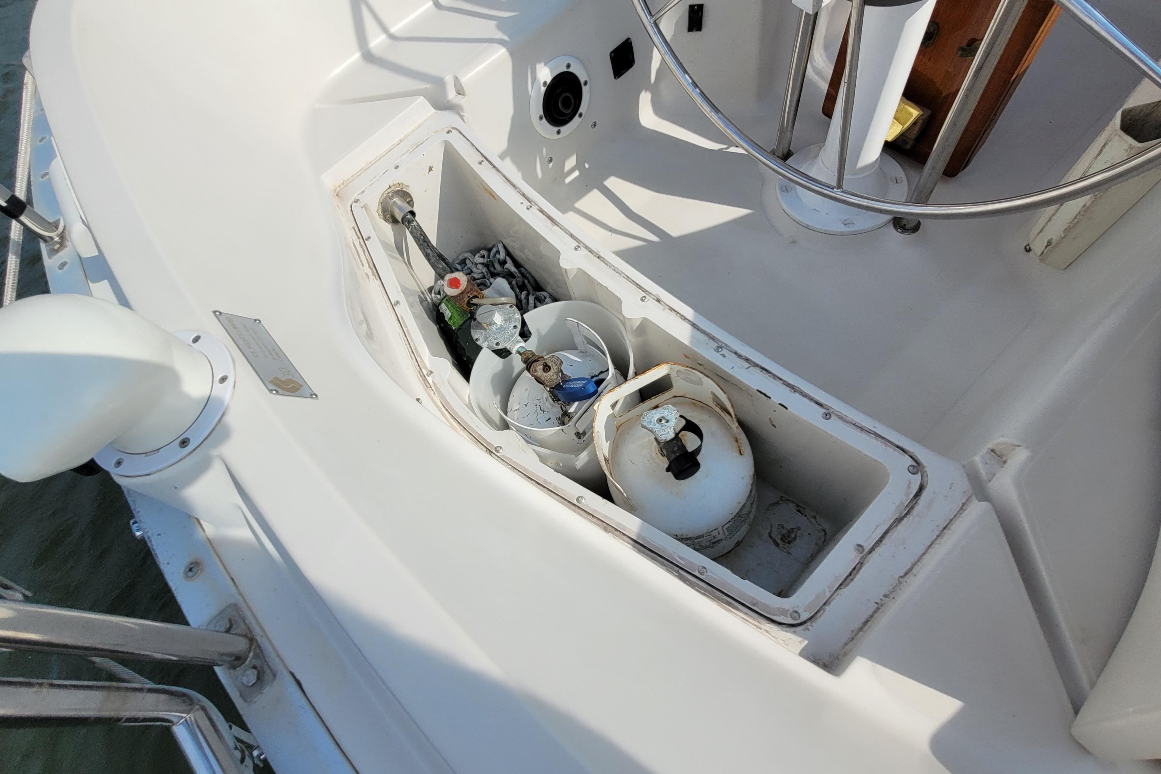 Open storage compartment on 1987 CS 30 boat with propane tank and equipment.