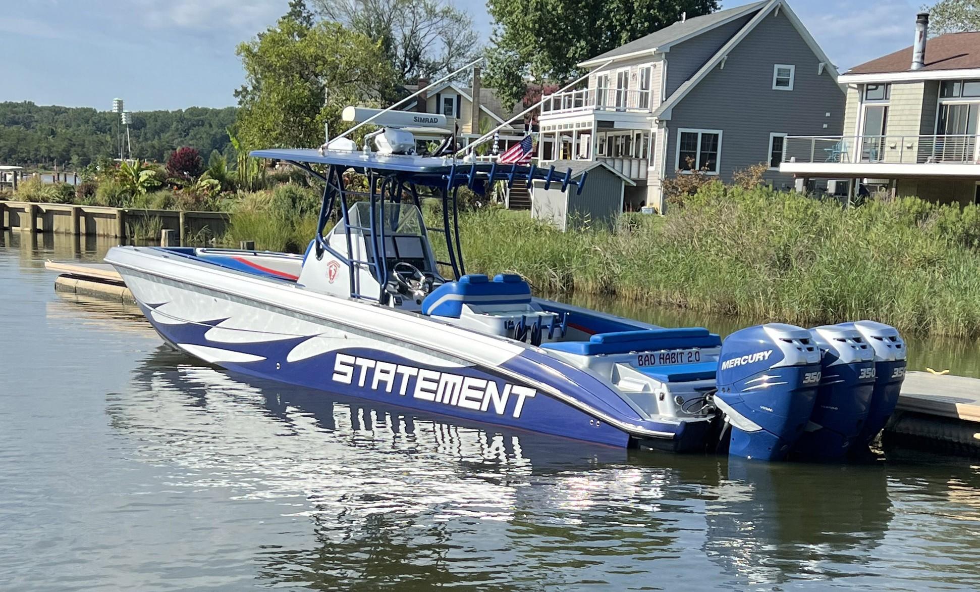 2011 Statement 380 Open boat docked with triple Mercury engines.