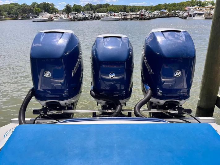 Yacht Photos Pics Three powerful outboard motors on a 2011 Statement 380 Open boat, docked by a marina.