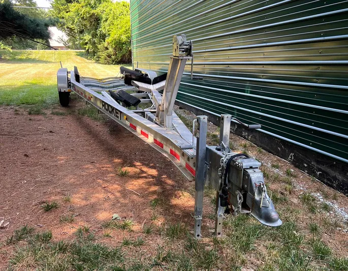  Yacht Photos Pics Trailer for Statement 380 Open 2011, parked on grass beside a metal building.