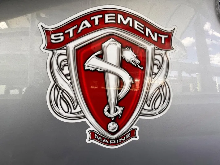  Yacht Photos Pics Statement Marine logo on 2011 Statement 380 Open boat, featuring a red and silver shield design.