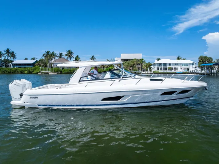 Tide Chaser Yacht Photos Pics 2022 Intrepid 438 Evolution boat cruising on a sunny day near waterfront homes.