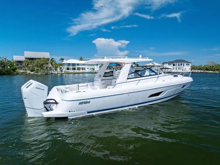 Tide Chaser Yacht Photos Pics 2022 Intrepid 438 Evolution boat cruising on a sunny day near waterfront homes.