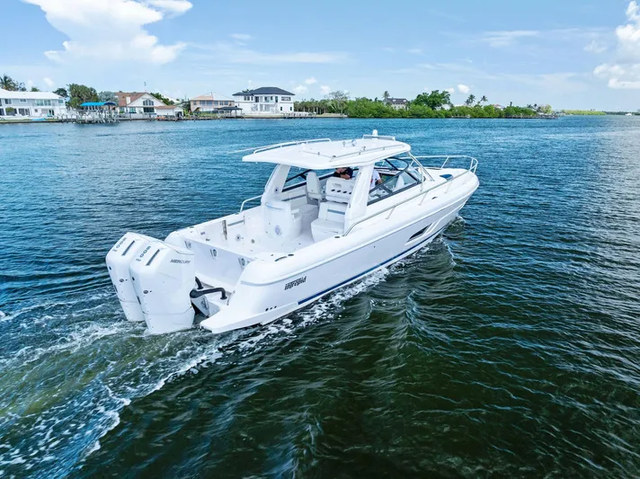 Tide Chaser Yacht Photos Pics 2022 Intrepid 438 Evolution yacht cruising on a sunny day near waterfront homes.