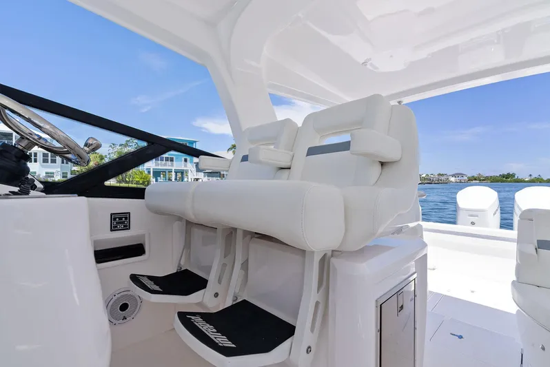 Tide Chaser Yacht Photos Pics 2022 Intrepid 438 Evolution boat interior with white seating and steering wheel.