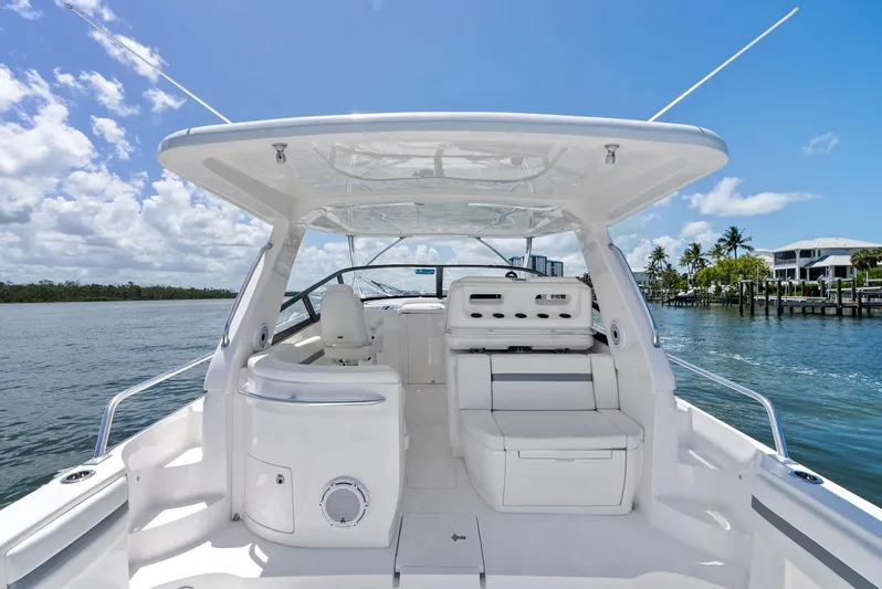 Tide Chaser Yacht Photos Pics 2022 Intrepid 438 Evolution boat interior with seating, under a clear blue sky.