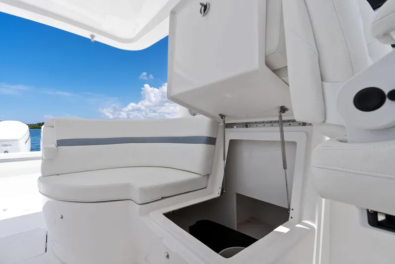 Tide Chaser Yacht Photos Pics 2022 Intrepid 438 Evolution boat interior with open storage compartment and white seating.