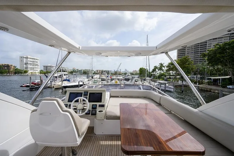 Vivere Yacht Photos Pics Flybridge view of 2016 Azimut 50 yacht docked in a marina, featuring helm and seating area.