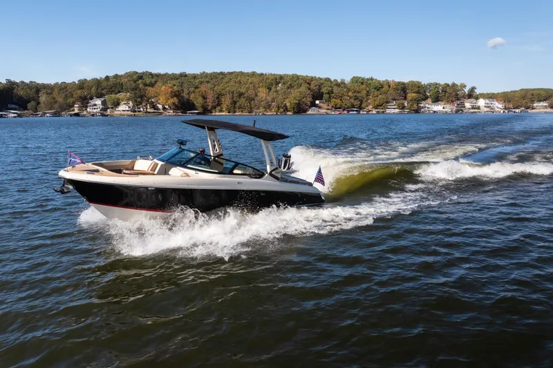  Yacht Photos Pics 2026 Chris-Craft Sportster 28 cruising on a scenic lake under clear skies.
