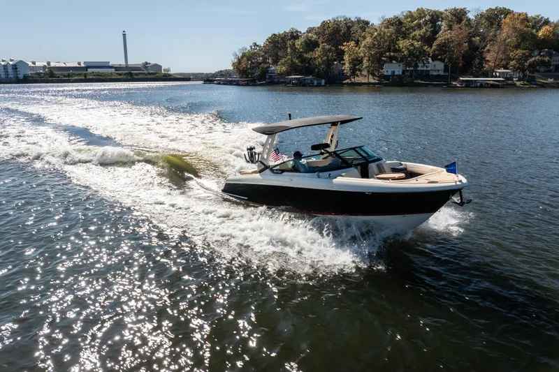  Yacht Photos Pics 2026 Chris-Craft Sportster 28 cruising on a sunny lake with scenic background.