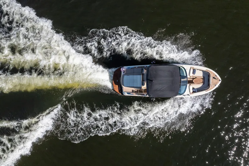  Yacht Photos Pics Aerial view of 2026 Chris-Craft Sportster 28 boat cruising on water, creating a wake.