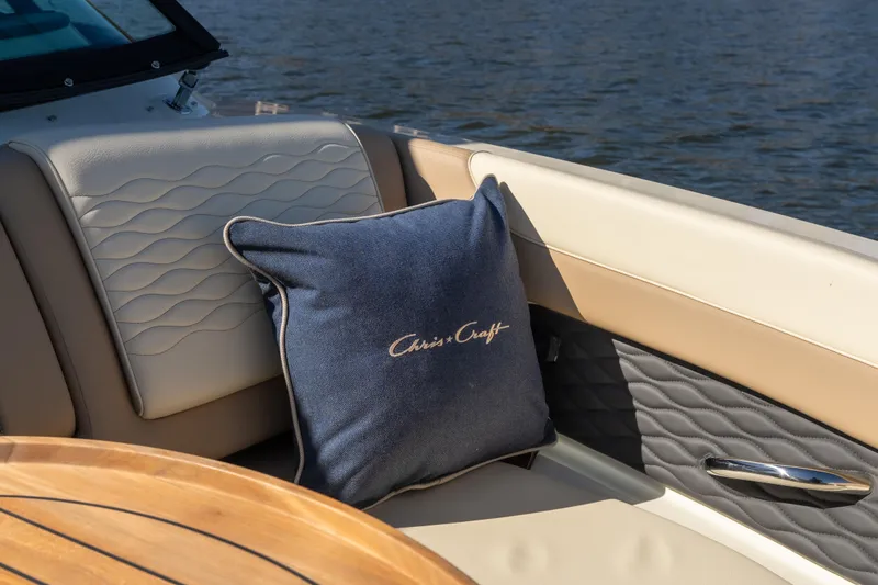  Yacht Photos Pics 2026 Chris-Craft Sportster 28 interior with logo pillow, elegant seating, and wooden table.