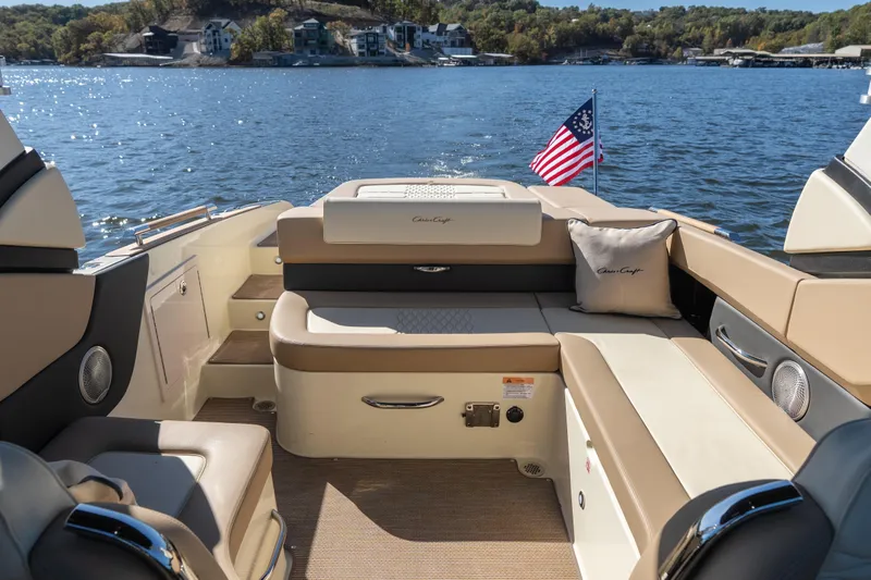  Yacht Photos Pics 2026 Chris-Craft Sportster 28 boat interior with seating, American flag, and scenic lake view.