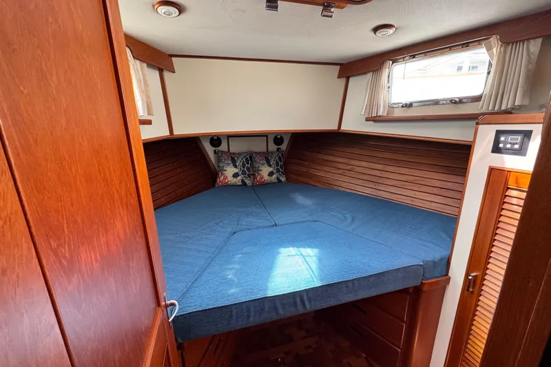 Driftwood Yacht Photos Pics Cozy cabin interior of 2000 Grand Banks 52 Europa yacht with wooden accents and blue bedding.