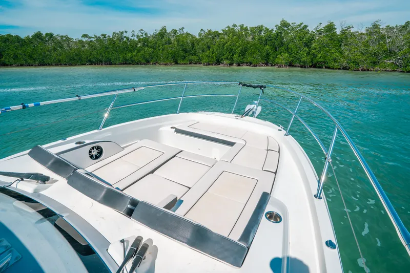  Yacht Photos Pics 2021 Jeanneau Leader 12.5 WA boat on turquoise water near lush green shoreline.