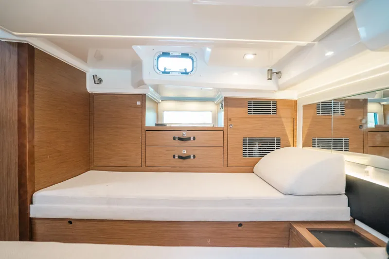  Yacht Photos Pics 2021 Jeanneau Leader 12.5 WA cabin interior with wooden finish and comfortable bedding.