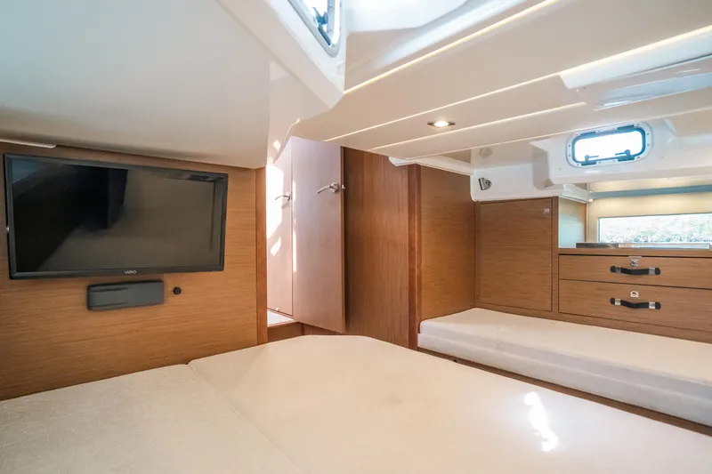  Yacht Photos Pics Interior cabin of 2021 Jeanneau Leader 12.5 WA with TV and wooden furnishings.
