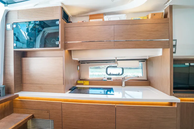  Yacht Photos Pics Modern kitchen interior of 2021 Jeanneau Leader 12.5 WA yacht with wood cabinetry.