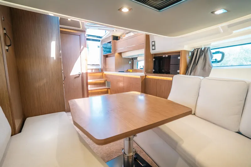  Yacht Photos Pics Interior of 2021 Jeanneau Leader 12.5 WA yacht with modern wood finish and seating area.