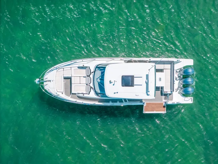  Yacht Photos Pics Aerial view of 2021 Jeanneau Leader 12.5 WA boat on clear green water.