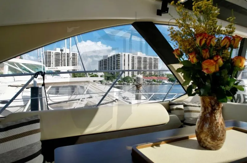 Saint George Yacht Photos Pics Interior view of 2015 Azimut 55S yacht with floral arrangement and marina backdrop.