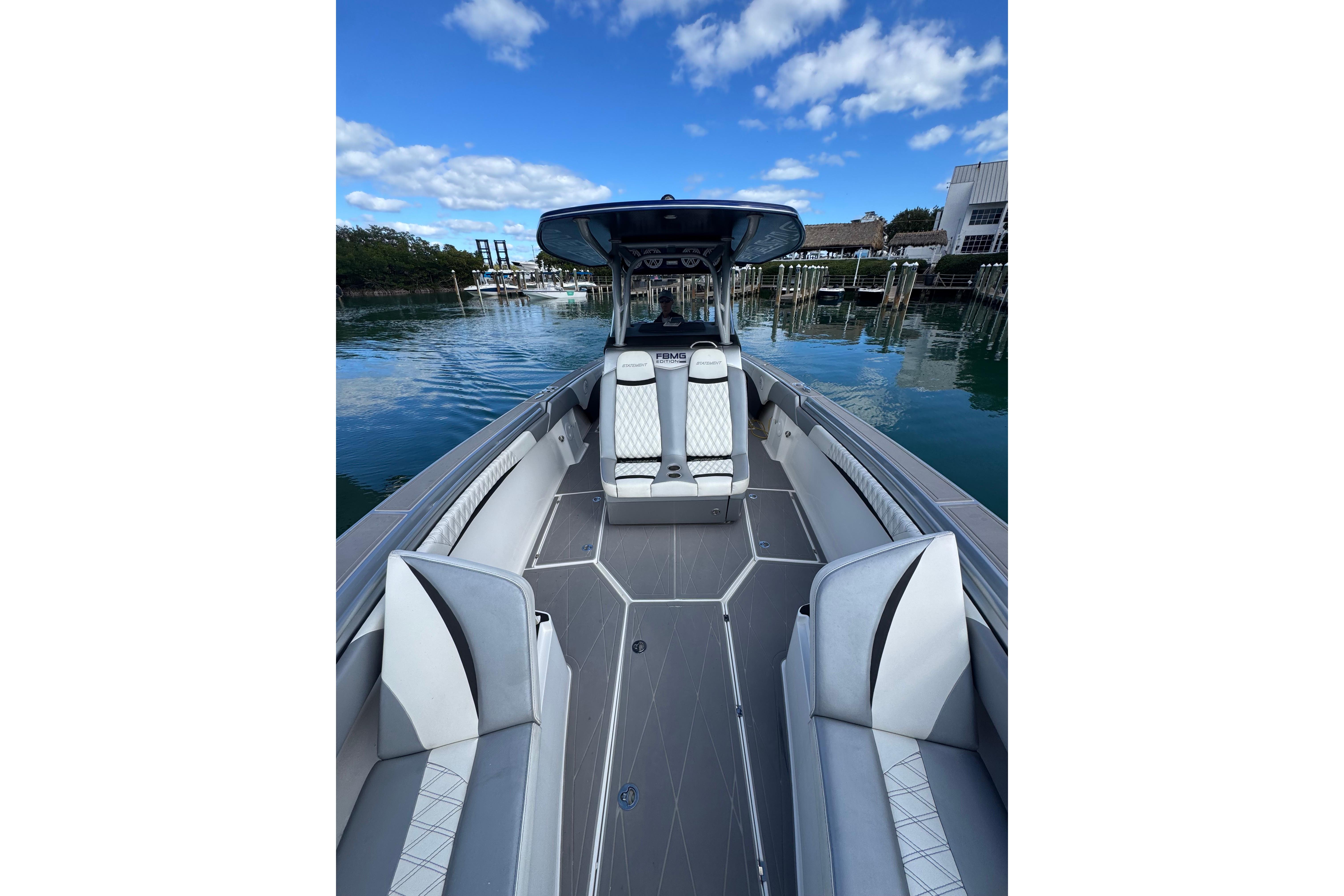 2019 Statement 380 Open boat with sleek seating, docked on a sunny day.