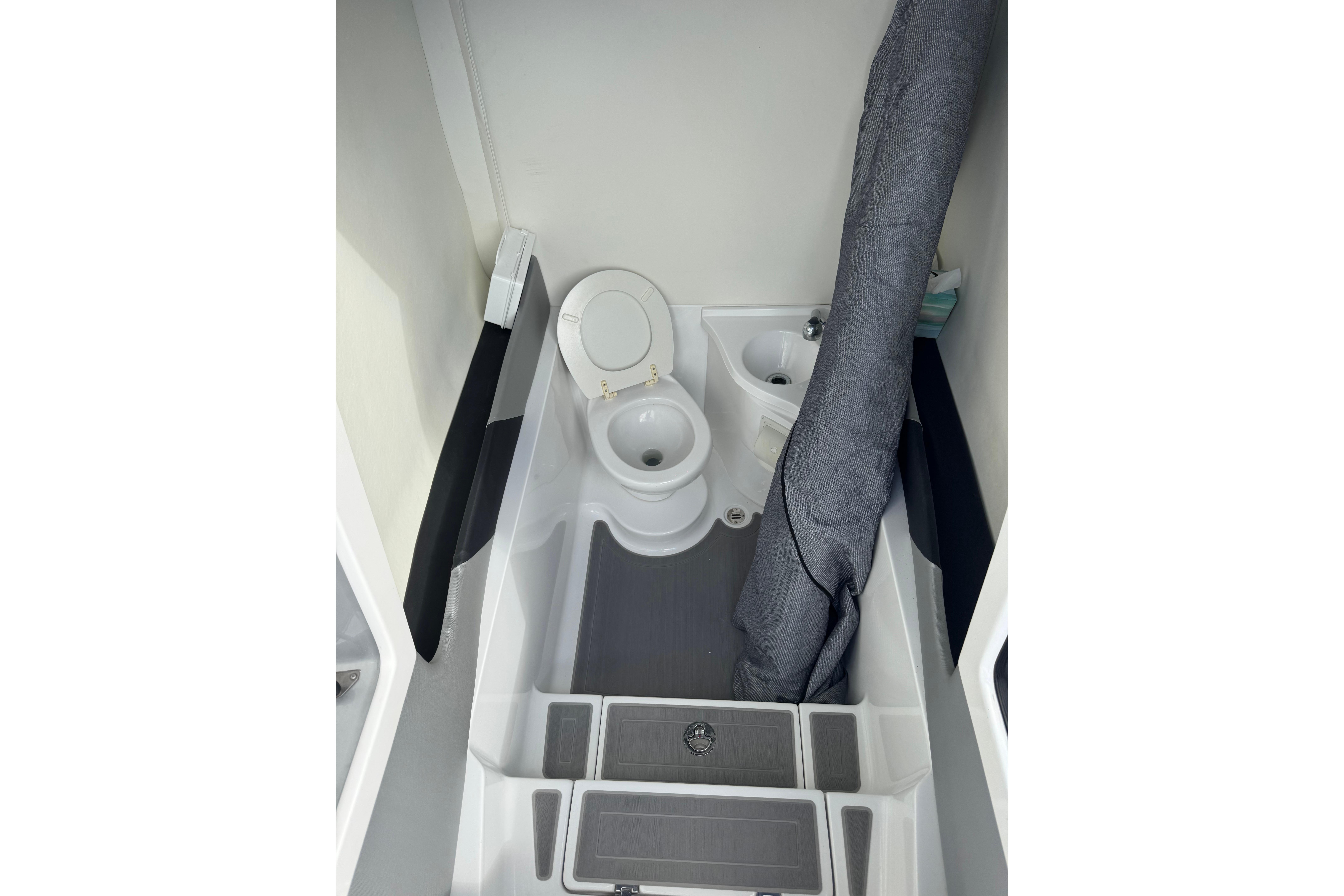 Compact bathroom in 2019 Statement 380 Open boat, featuring toilet and sink.