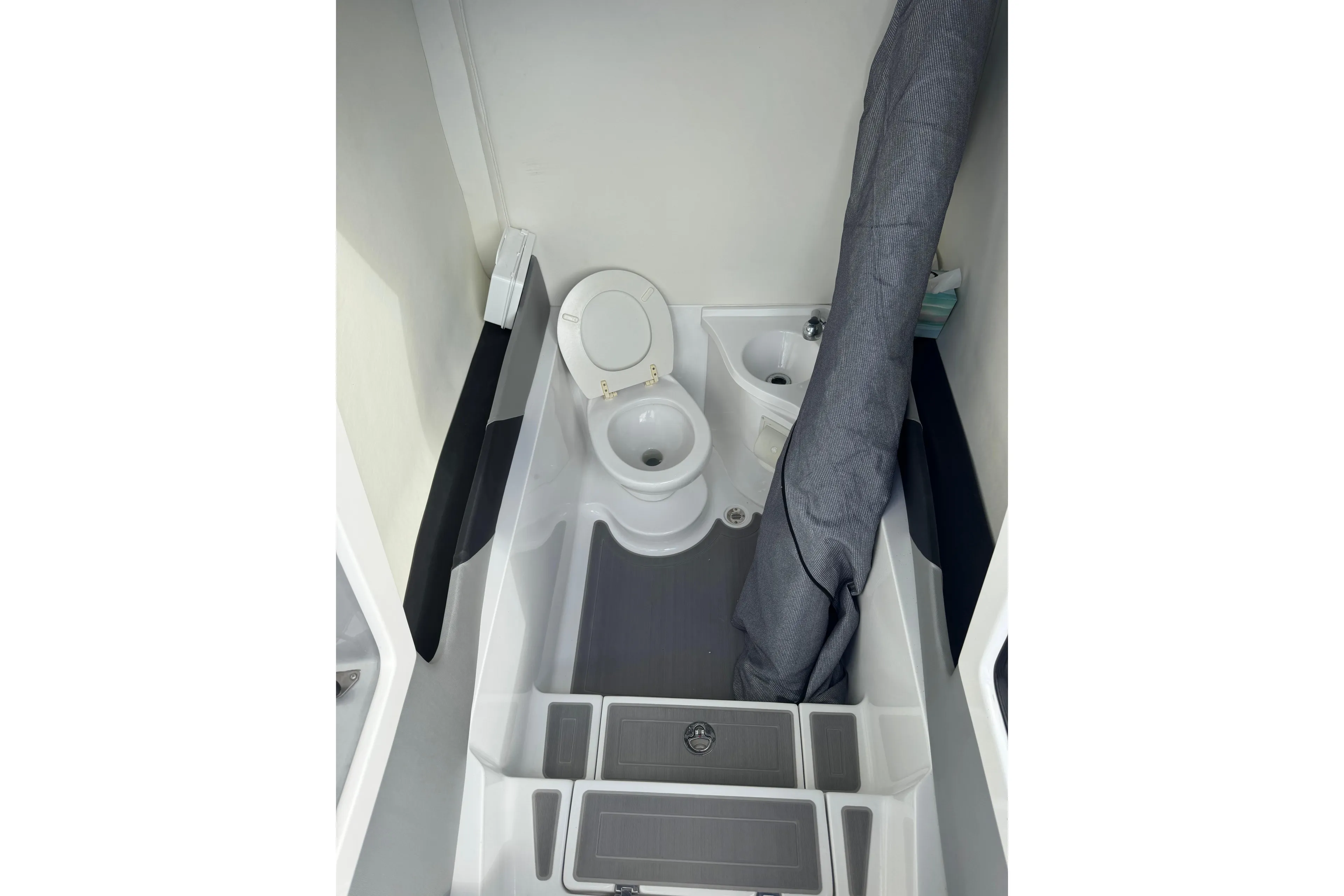 Compact bathroom in 2019 Statement 380 Open boat, featuring toilet and sink.