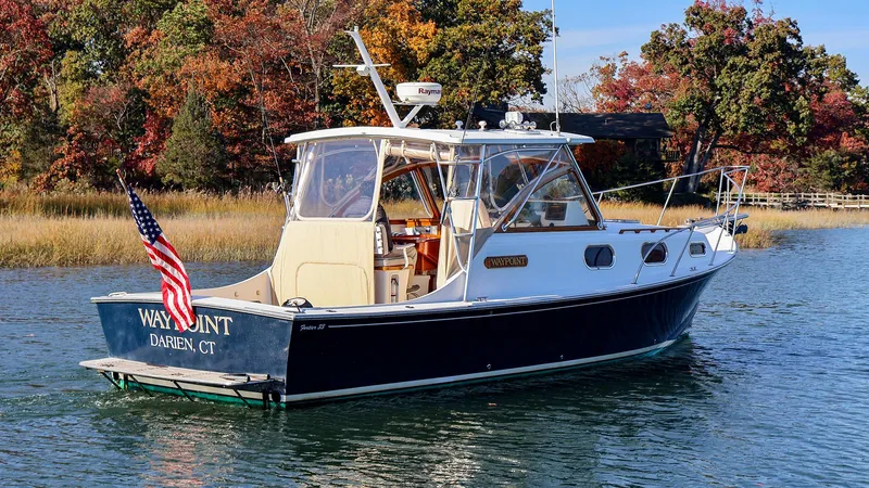 4804mm Yacht Photos Pics 2008 Fortier 33 boat on water, American flag, autumn trees in background.