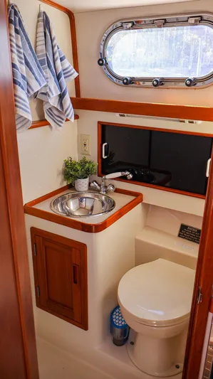4804mm Yacht Photos Pics Compact bathroom in 2008 Fortier 33 boat with sink, toilet, and window.