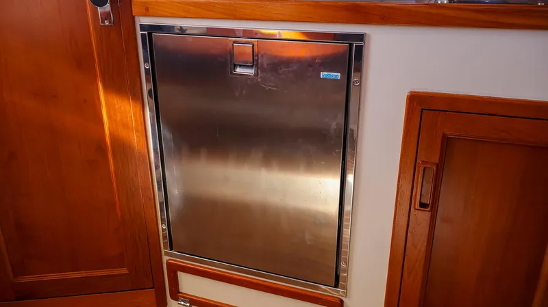 4804mm Yacht Photos Pics Stainless steel refrigerator in 2008 Fortier 33 boat interior with wooden cabinetry.