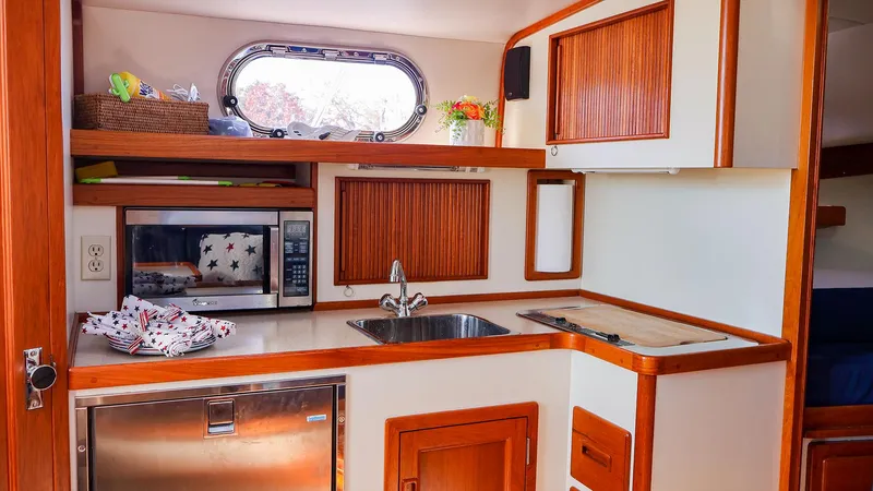 4804mm Yacht Photos Pics 2008 Fortier 33 boat kitchen with wood accents, sink, and microwave.