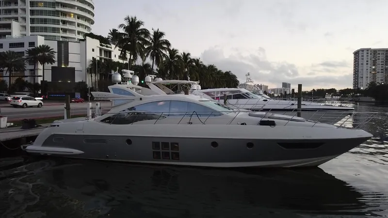 Life Is Great Yacht Photos Pics 2007 Azimut 62S yacht docked at a marina with palm trees and buildings in the background.