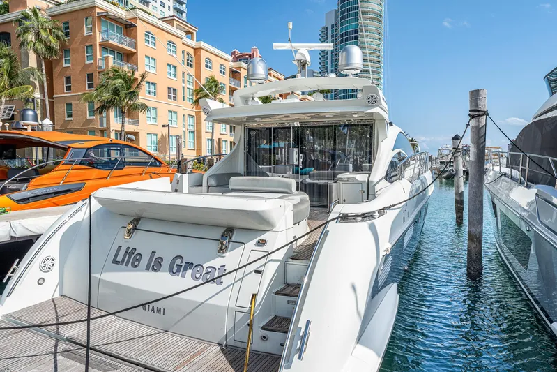 Life Is Great Yacht Photos Pics 2007 Azimut 62S yacht docked in Miami marina with cityscape background.