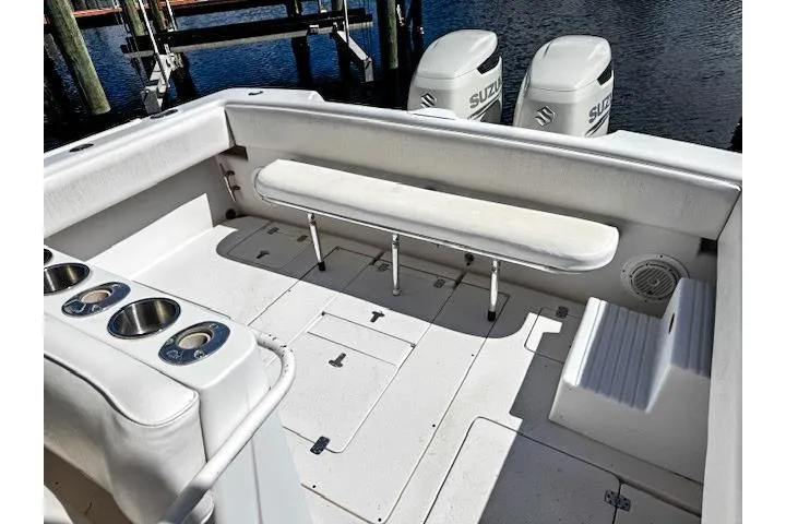  Yacht Photos Pics 1999 Intrepid 356 boat interior with seating and Suzuki engines in a marina setting.