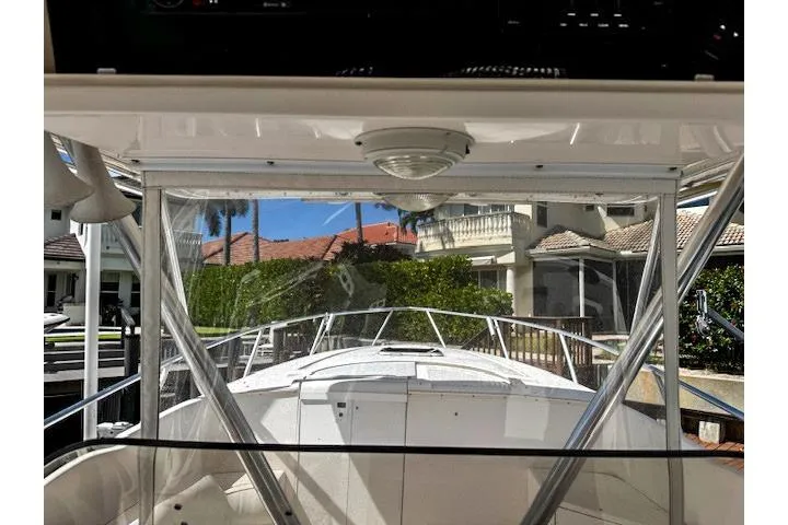  Yacht Photos Pics 1999 Intrepid 356 boat interior view with clear canopy and residential backdrop.