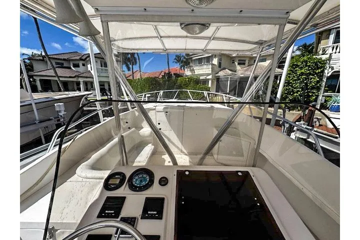  Yacht Photos Pics 1999 Intrepid 356 boat cockpit with control panel, docked near waterfront homes.
