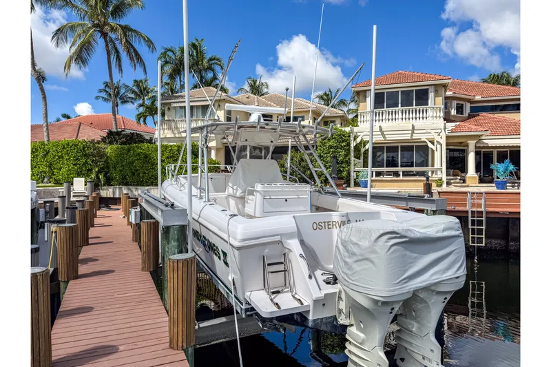  Yacht Photos Pics 1999 Intrepid 356 boat docked near luxury waterfront homes, surrounded by palm trees.