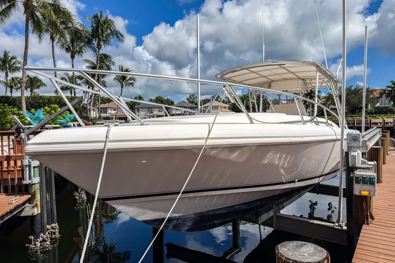  Yacht Photos Pics 1999 Intrepid 356 boat docked, surrounded by palm trees and blue sky.