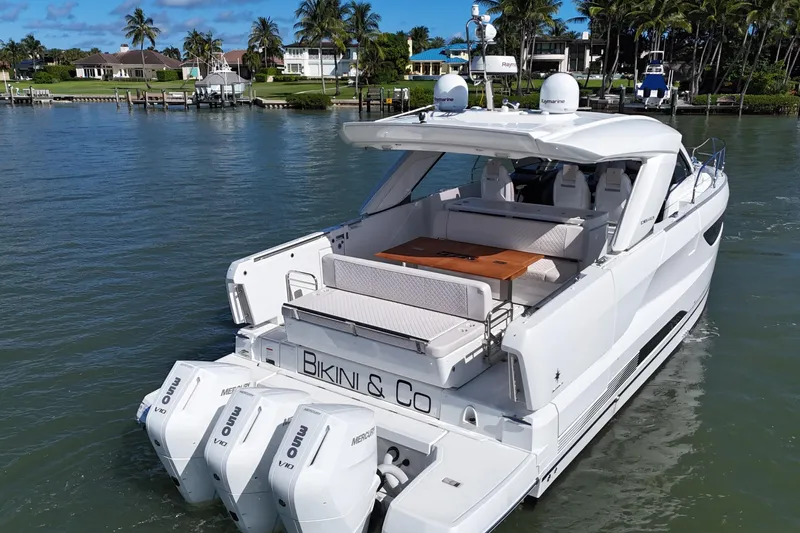  Yacht Photos Pics 2024 Jeanneau DB43 yacht with triple Mercury outboards, cruising in a scenic waterfront setting.