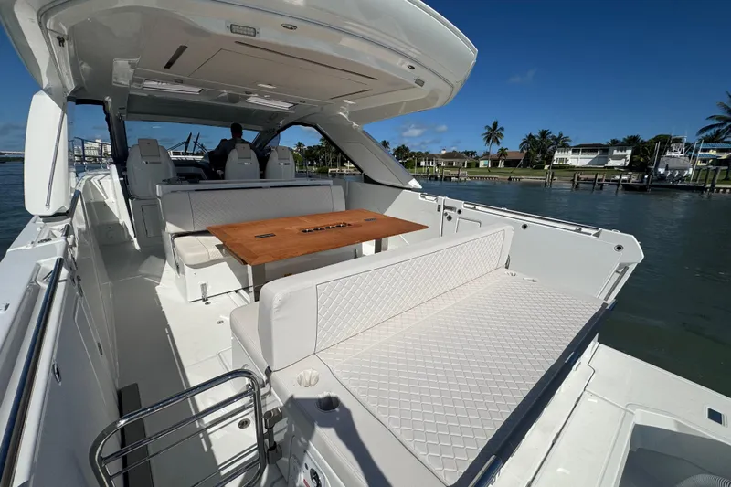  Yacht Photos Pics 2024 Jeanneau DB43 yacht interior with seating and table, docked by waterfront homes.